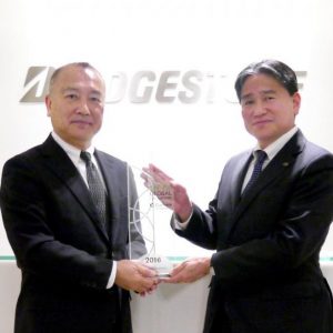クラリベイト アナリティクの日野・日本代表（左）からトロフィーを授与されるれる荒木充・知的財産本部長